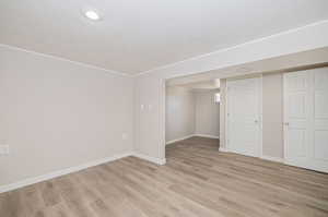 Primary bedroom with light hardwood / wood-style flooring and a closet