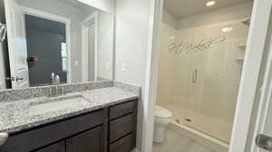 Bathroom featuring vanity, an enclosed shower, and toilet