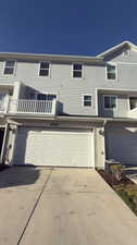 Townhome / multi-family property featuring a balcony and a garage