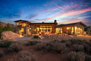 Back house at dusk with a balcony and a patio area