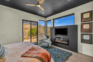 Bedroom featuring ceiling fan, access to exterior, and carpet floors