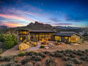 Back house at dusk with a mountain view, a fire pit, and a patio area