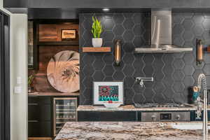 Kitchen with wall chimney range hood, beverage cooler, and decorative backsplash