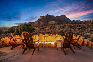 Patio terrace at dusk featuring an outdoor fire pit and a mountain view