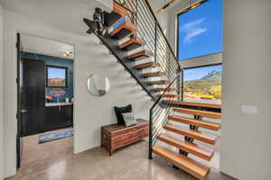 Stairs featuring concrete flooring and a mountain view