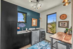 Laundry room with sink, a wealth of natural light, and washing machine and dryer