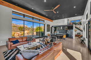 Living room with ceiling fan, a mountain view, and a high ceiling