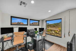 Office space with lofted ceiling and hardwood / wood-style floors