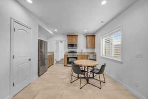 Kitchen with stainless steel appliances, a textured ceiling, light tile patterned floors, and sink