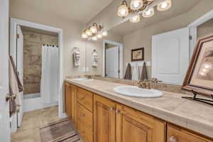 Full bathroom featuring tile patterned flooring, vanity, toilet, and shower / bathtub combination with curtain