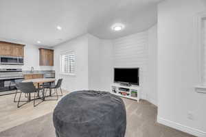 Living room with light carpet, a textured ceiling, and sink