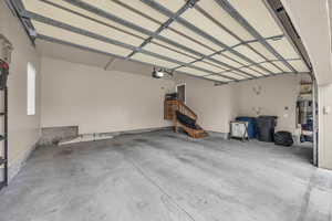 Garage featuring water heater and a garage door opener