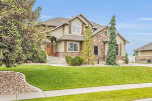 View of front of home featuring cooling unit and a front yard