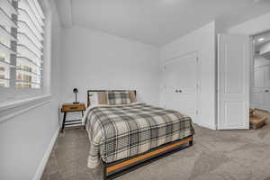 Carpeted bedroom with a textured ceiling and a closet