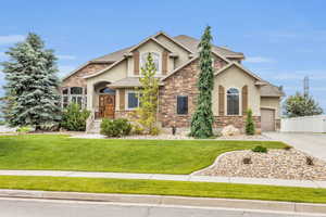 Craftsman inspired home with a front yard and a garage