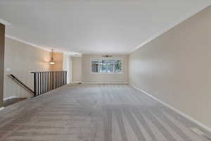 Carpeted spare room with crown molding