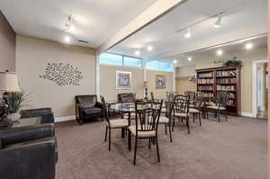 Dining area with carpet floors and track lighting