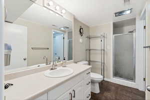 Bathroom featuring tile patterned floors, walk in shower, vanity, and toilet