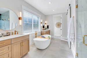 Primary bathroom featuring vanity, shower with separate bathtub, and tile patterned floors