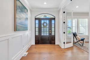 Entrance foyer featuring light wood-type flooring and ornamental molding