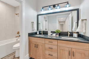 Full bathroom featuring wood-type flooring, vanity, toilet, and tiled shower / bath