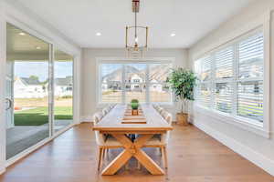 Dining area with an inviting chandelier, hardwood / wood-style floors, and plenty of natural light