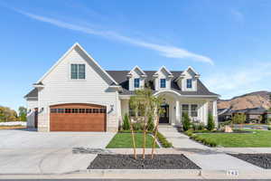 View of front facade featuring a mountain view, a garage, and a front lawn