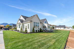 View of side of home with a mountain view, central AC, and a yard