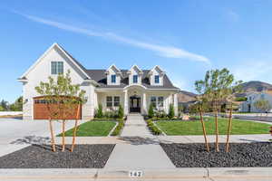 View of front facade with a front yard, a mountain view, and a garage