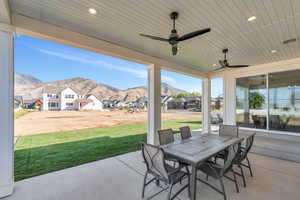 Back patio / terrace with ceiling fan and a mountain view