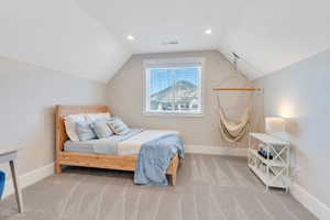 Bedroom with carpet flooring and vaulted ceiling