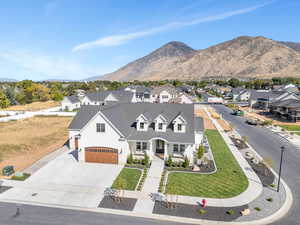 View of front of house featuring a garage, a mountain view, and a front yard