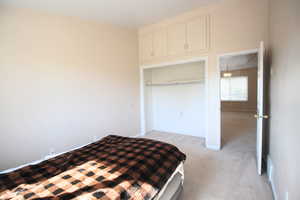 Bedroom 3 with light colored carpet, a textured ceiling, a closet, and a chandelier