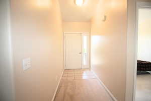 Large Entry Hallway featuring light carpet and a textured ceiling