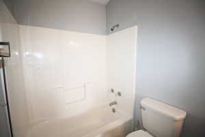 Bathroom with shower / bathing tub combination and toilet