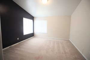 Carpeted Master Bedroom with vaulted ceiling and a textured ceiling