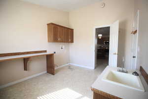 Clothes washing area featuring cabinets, light colored carpet, hookup for a washing machine, electric dryer hookup, and a textured ceiling