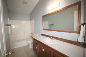 Full bathroom featuring vanity, washtub / shower combination, and toilet