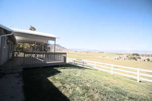 View of yard featuring a deck with mountain view and a rural view