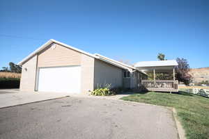 View of side of property featuring a garage and a yard