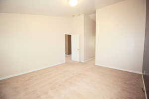 Master Bedroom with lofted ceiling, light colored carpet, and a textured ceiling