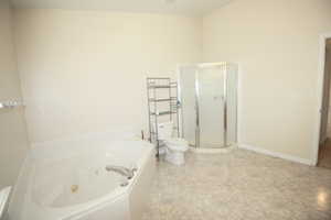 Master Bathroom featuring toilet and independent shower and huge jetted bath