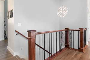 Stairway featuring a chandelier and hardwood / wood-style flooring