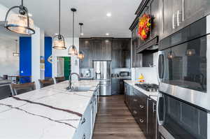 Kitchen Island with sink, stainless steel appliances and breakfast bar area