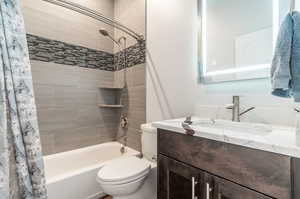 Full bathroom featuring shower / bath combo with shower curtain, vanity, and toilet