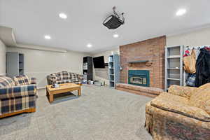 Carpeted living room featuring ornamental molding and a brick fireplace