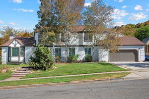 View of front facade featuring a front yard and a garage