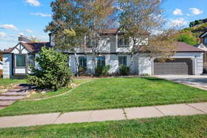 View of front of property with a garage and a front yard