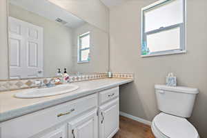 Bathroom featuring hardwood / wood-style floors, vanity, and toilet