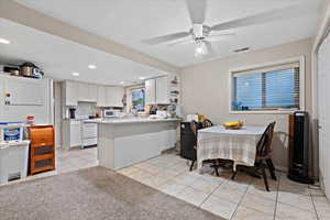 Dining room featuring ceiling fan, sink, light tile patterned floors, and a textured ceiling